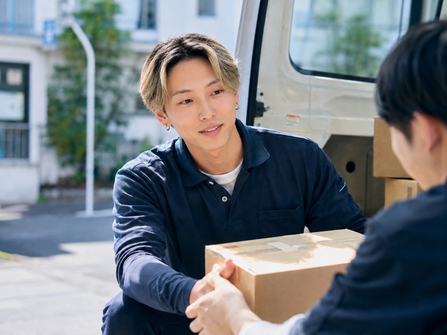 車から荷物を受け渡すスタッフ